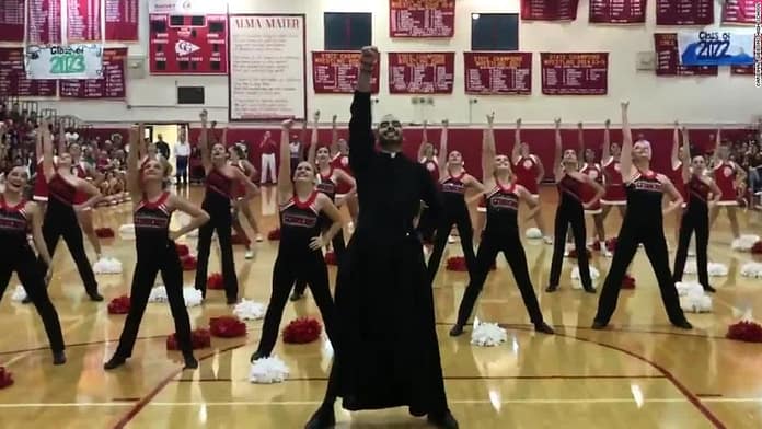 Dancing priest wows students at pep rally