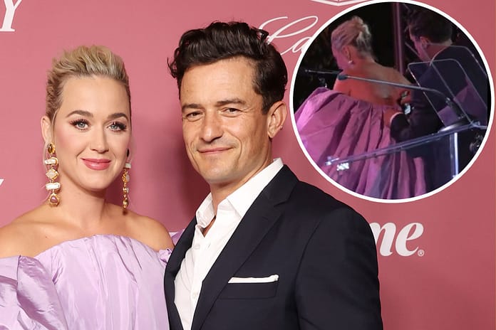 Orlando Bloom helps Katy Perry fix her dress at Power of Women event